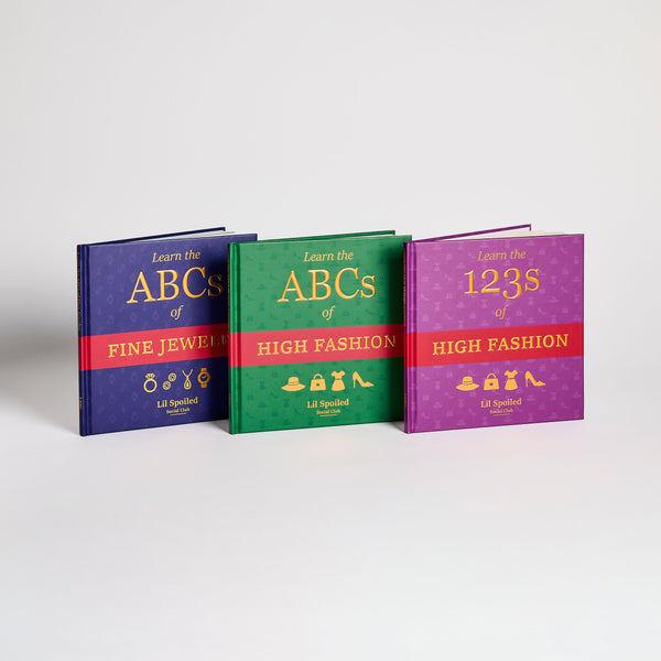 Three colorful books titled 'Learn the ABCs of Fine Jewelry', 'Learn the ABCs of High Fashion', and 'Learn the 123s of High Fashion' on a gradient background.