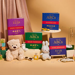 Collection of children's books on a shelf with toys and decorative items. The books are Lil Spoiled Social Club ABCs and 123s books.