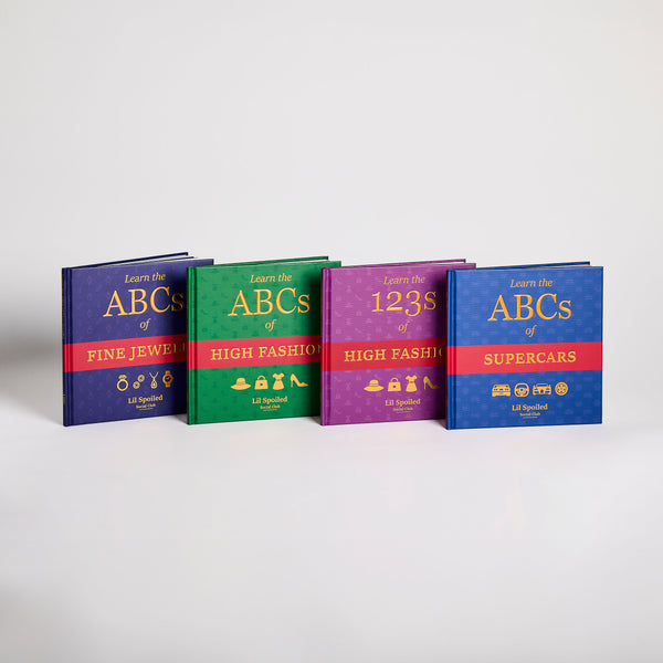 Four colorful books titled 'Learn the ABCs of Fine Jewelry', 'Learn the ABCs of High Fashion', 'Learn the 123s of High Fashion', and 'Learn the ABCs of Supercars' on a light gray background.