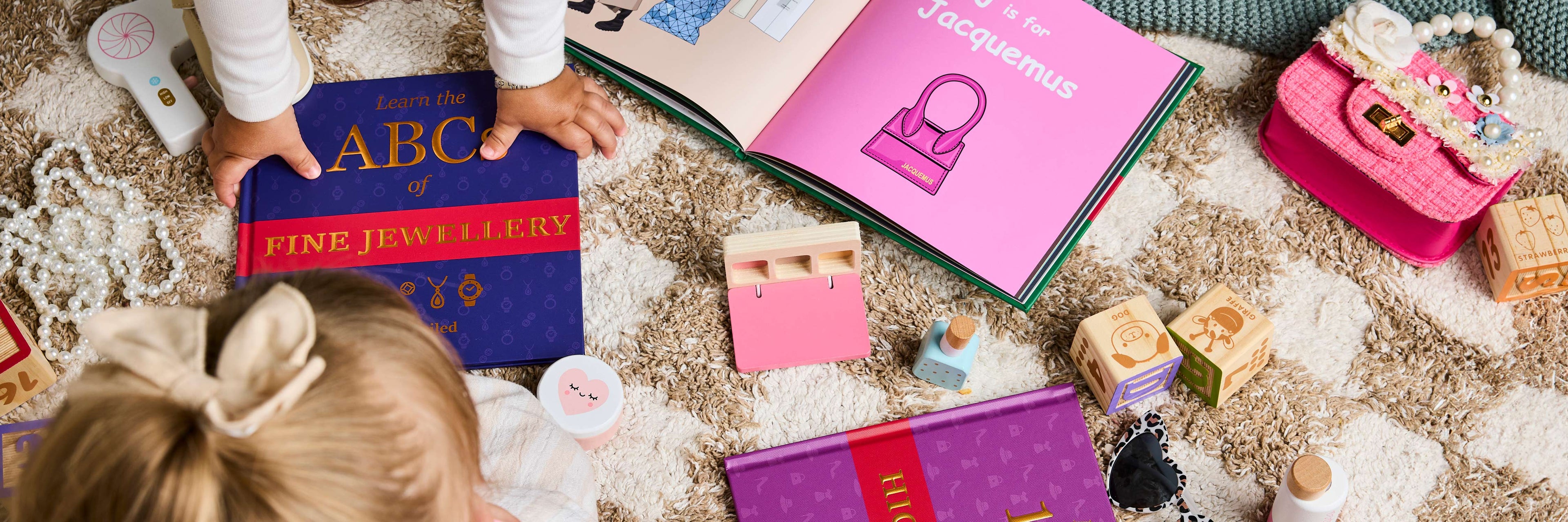 Children's books on a carpet with toys around
